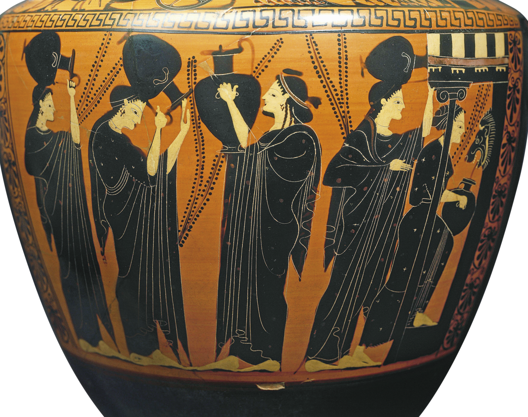 Fotografia. Detalhe de um vaso com a pintura na superfície amarelada. Mulheres de túnica preta seguram grandes jarros. Algumas estão com o jarro acima da cabeça.