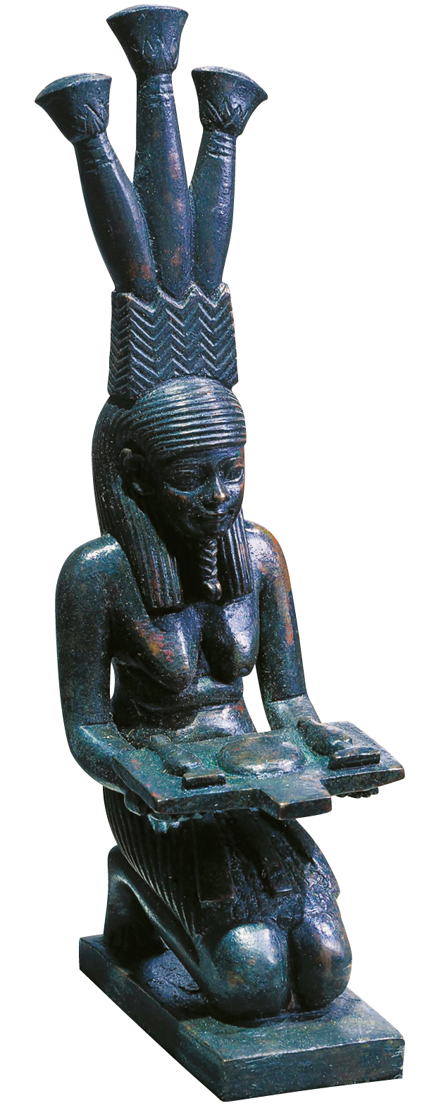 Fotografia. Escultura em pedra de uma mulher ajoelhada com uma bandeja nas mãos e alguns objetos sobre ela. O cabelo da mulher se estende até a altura dos ombros. Ela usa um adereço comprido na cabeça, com três hastes cilíndricas no topo.