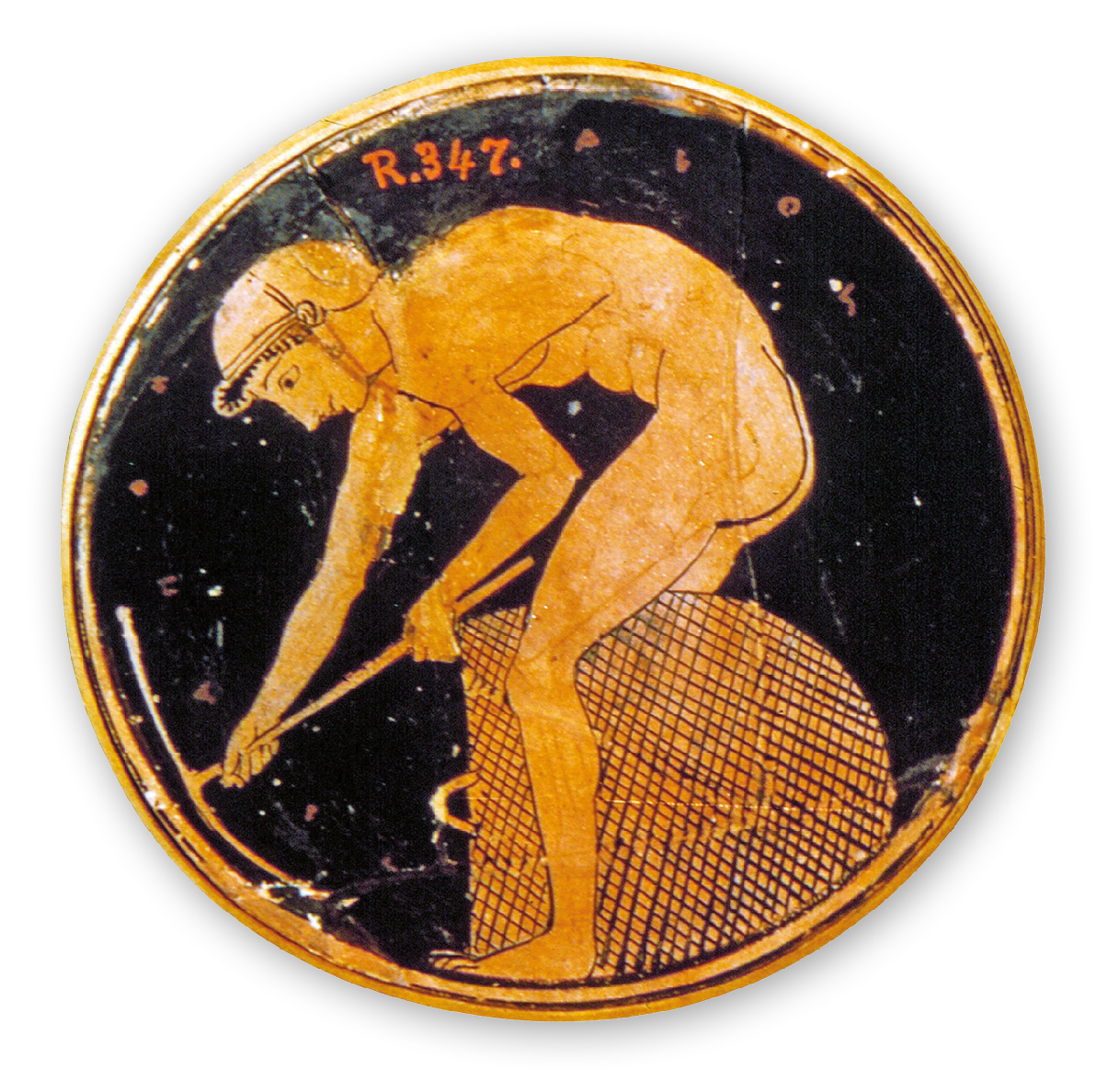 Fotografia. Artefato de cerâmica de formato circular. Na superfície o desenho dourado de um homem nu, usando capacete. Ele está de lado, com o corpo inclinado para frente, manuseando uma picareta. Ao lado de suas pernas, um grande cesto.