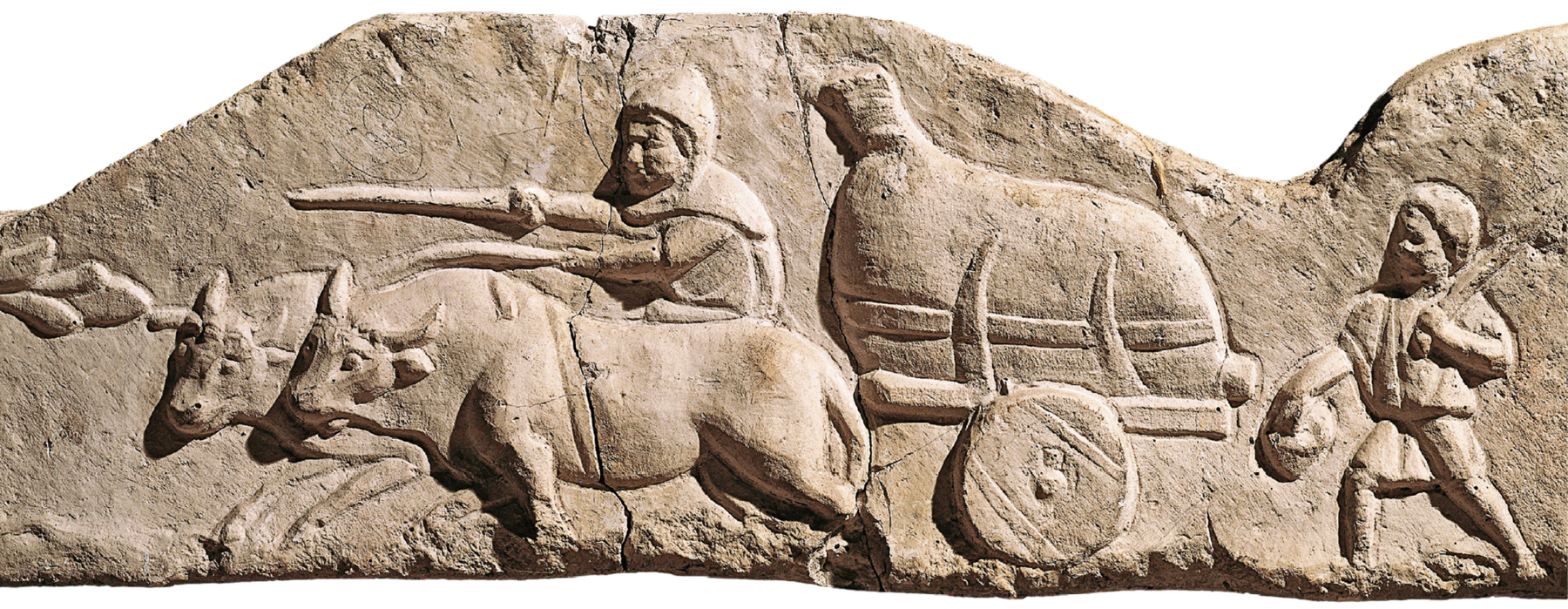 Escultura. Imagem esculpida em alto relevo em superfície rochosa. Representa um homem guiando bois que puxam uma carroça com uma grande sacola dentro. Atrás da carroça uma criança caminhando.