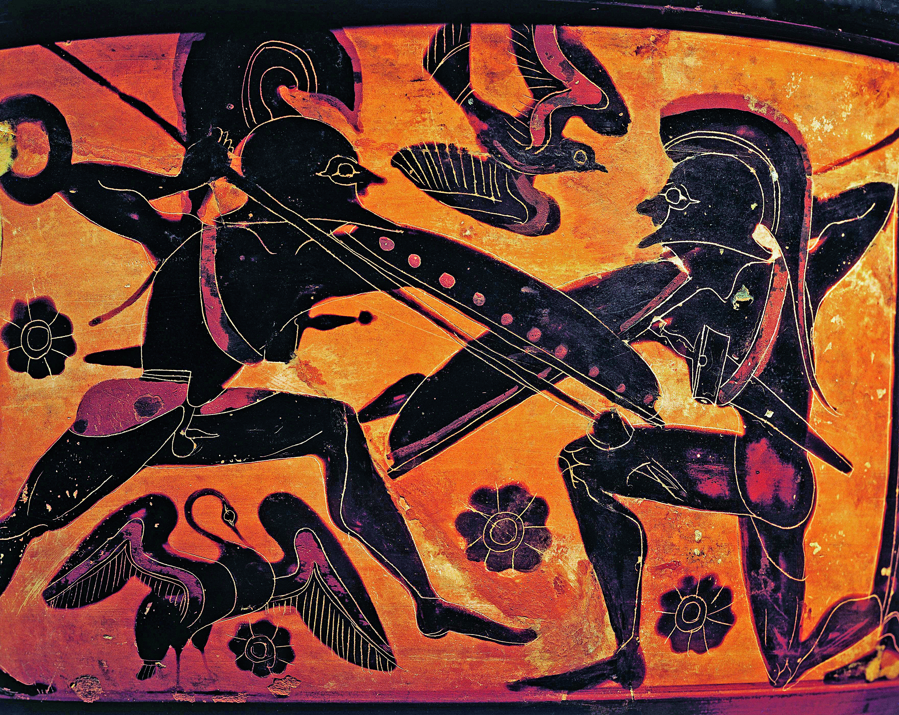 Fotografia. Destaque para a pintura de uma superfície amarela de um vaso. Dois guerreiros se enfrentando. Eles têm lanças e escudos. O guerreiro da direita está ajoelhado e o guerreiro da esquerda está com o corpo inclinado para frente, na direção de seu oponente.