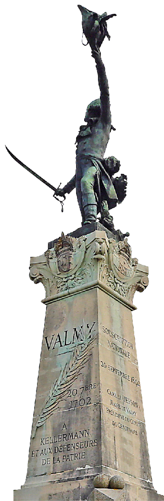 Fotografia. Monumento em pedra com uma estátua de bronze no topo. Ele tem inscrições em francês em sua superfície. A parte de cima é ornamentada. A estátua representa uma pessoa segurando uma espada com uma mão e erguendo o chapéu com outra.
