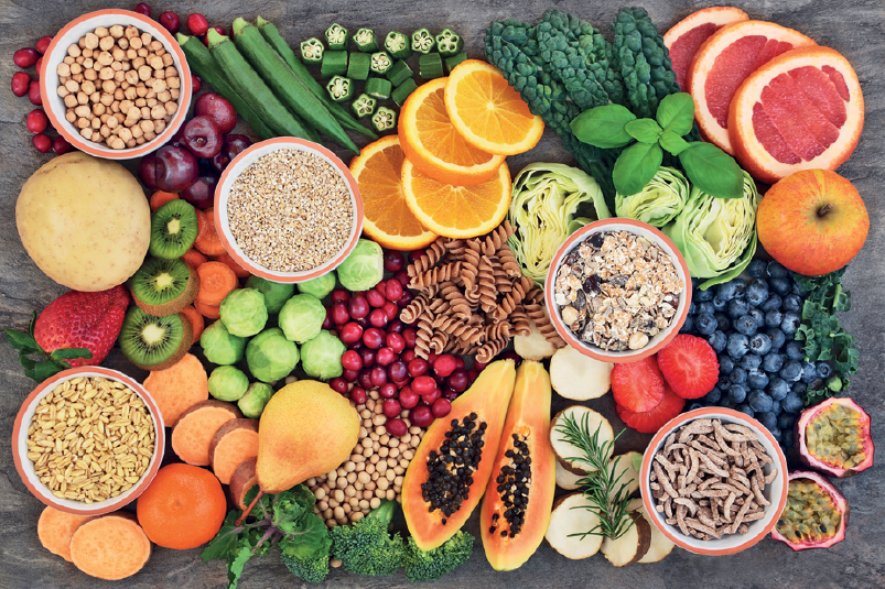 Fotografia. Vista geral vários legumes, verduras e frutas aglomerados um perto do outro como: laranjas, mexericas, kiwis, mamão, entre outros.