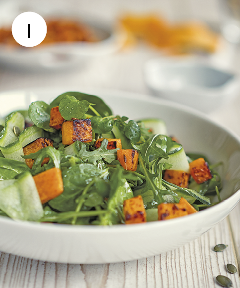Fotografia. Número um. Um prato sobre uma mesa cinza. Ele é arredondado em branco com alimentos dentro em verde, laranja e folhas verdes.