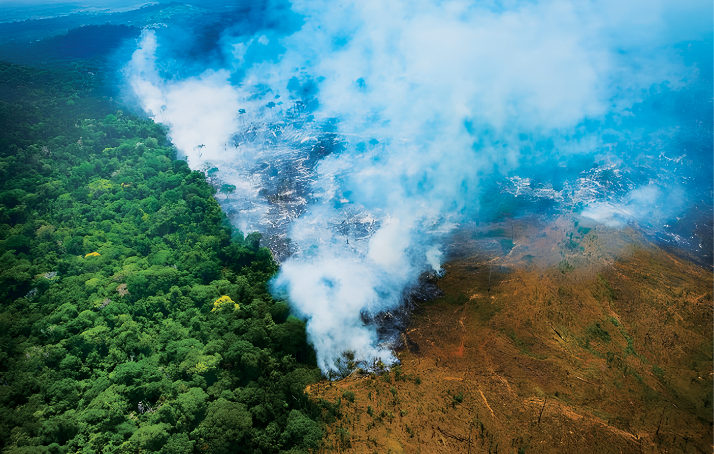 Fotografia aérea. Queimada na Amazônia. À direita, área desmatada com muita fumaça. À esquerda, parte da floresta.