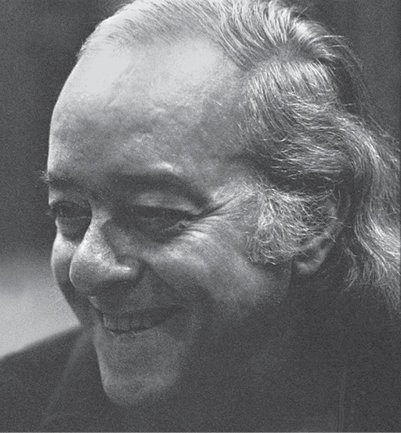 Fotografia. Em preto e branco. Vinicius de Moraes, com cerca de 60 anos. Tem a testa larga, cabelos grisalhos e ondulados, e está sorrindo.