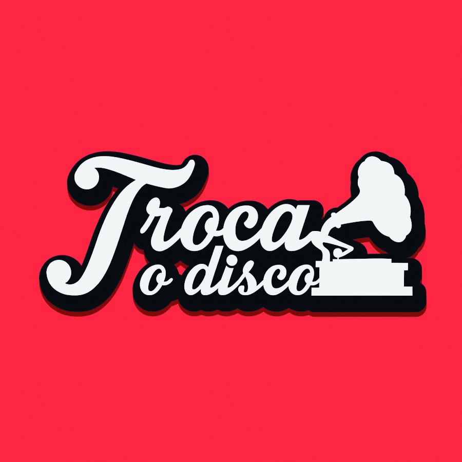 Logotipo. Fundo em vermelho, com texto em contorno preto, preenchida em branco: TROCA O DISCO. Na ponta da direita, um tocador de disco antigo em branco, com contorno preto.