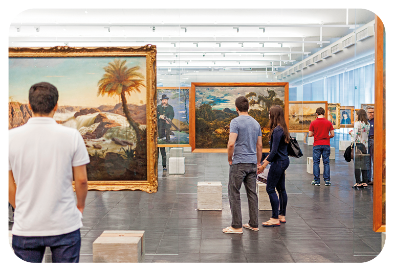Fotografia. Vista de pessoas em pé na frente e ao redor de quadros e pinturas em um museu de arte.