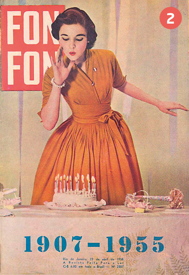 Capa de revista. Na parte superior esquerda, o título: FON FON. Abaixo, o título: 1907-1955. No centro, fotografia de uma mulher de cabelo curto penteado para o lado, usando vestido laranja, com a mão ao lado da boca e assoprando na direção de um bolo branco com velas.