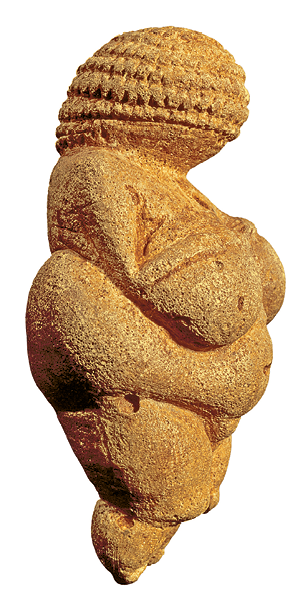 Escultura. Escultura marrom que apresenta a vista lateral de mulher nua com corpo robusto e superfície áspera. A região da cabeça tem aspecto granular.