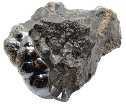 Fotografia. Uma pedra de hematita. Ela tem a coloração preta com manchas marrons. Possui formato irregular.