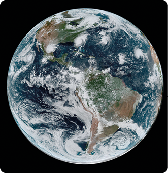 Fotografia. Sobre fundo escuro o planeta Terra, coberto por nuvens brancas. Possui extensa parte azul e trechos de terra à mostra.