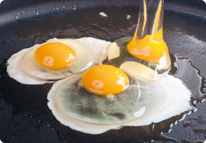 Fotografia. Três ovos sobre panela. Um dos ovos possui clara branca e os outros ainda com clara transparente.