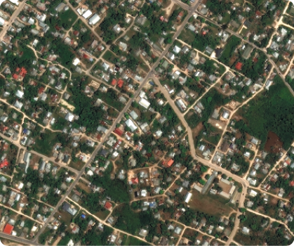 Fotografia de satélite de uma cidade, com áreas verdes de vegetação, ruas e construções.