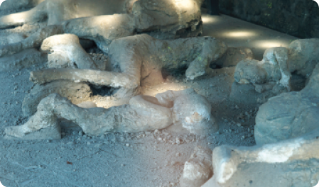 Fotografia de corpos formados por material com aparência de rocha, deitados no chão em diferentes posições.
