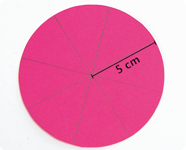 Fotografia. Um círculo de cartolina cor-de-rosa com oito partes iguais e raio de 5 centímetros.