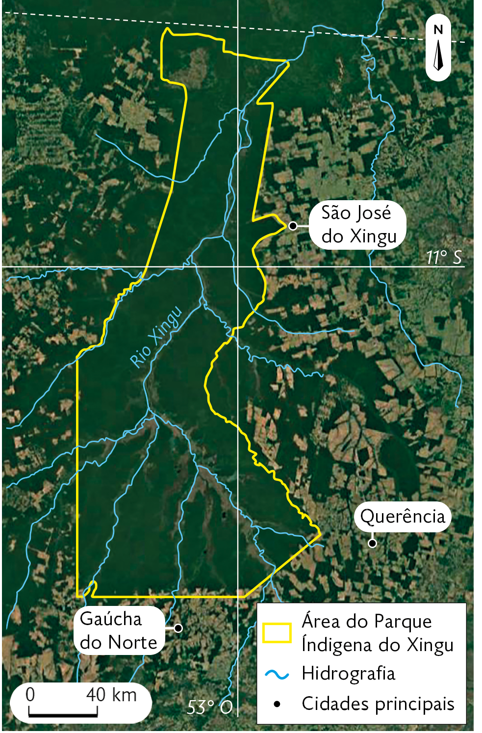 Fotografia. Imagem de Satélite destacando a área do Parque Indígena do Xingu, uma área coberta por vegetação, ao redor do Rio Xingu. Também estão destacadas as principais cidades: São José do Xingu, Querência e Gaúcha do Norte. No canto superior direito, seta apontando para o norte e no canto inferior esquerdo, a escala: 40 quilômetros por centímetro.
