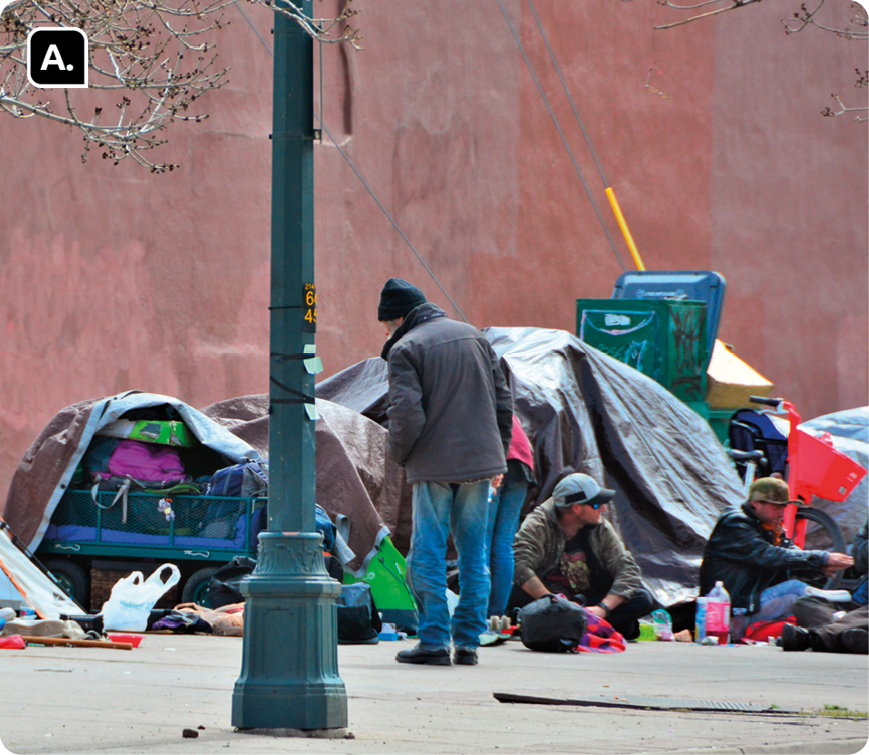 Fotografia A. Algumas pessoas em uma rua, ao lado de barracas com tecidos e objetos espalhados. Algumas delas estão sentadas.