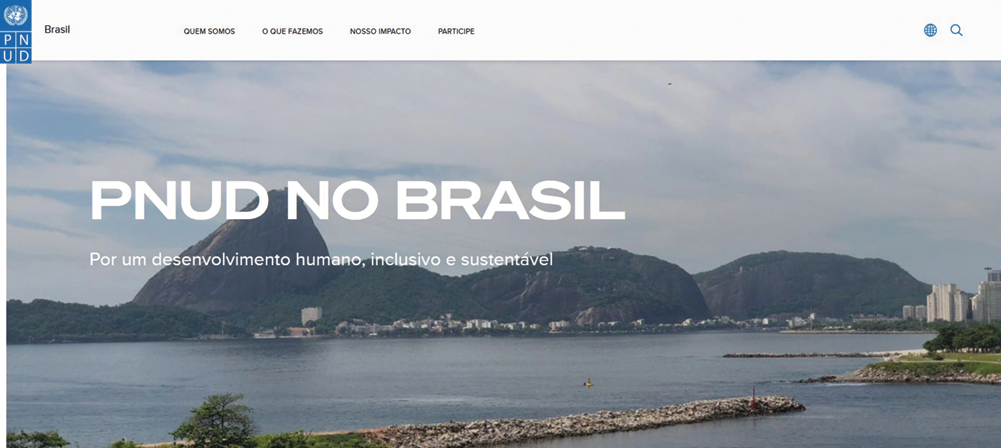 Página de site com a inscrição: PNUD NO BRASIL. Ao fundo, foto da orla do Rio de Janeiro, com formações rochosas.