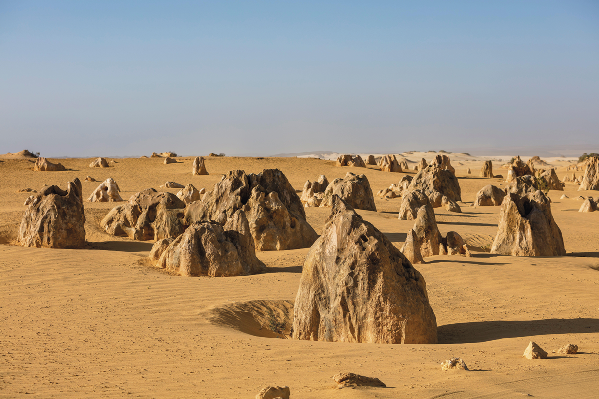 Fotografia. Deserto com diversas rochas espalhadas.