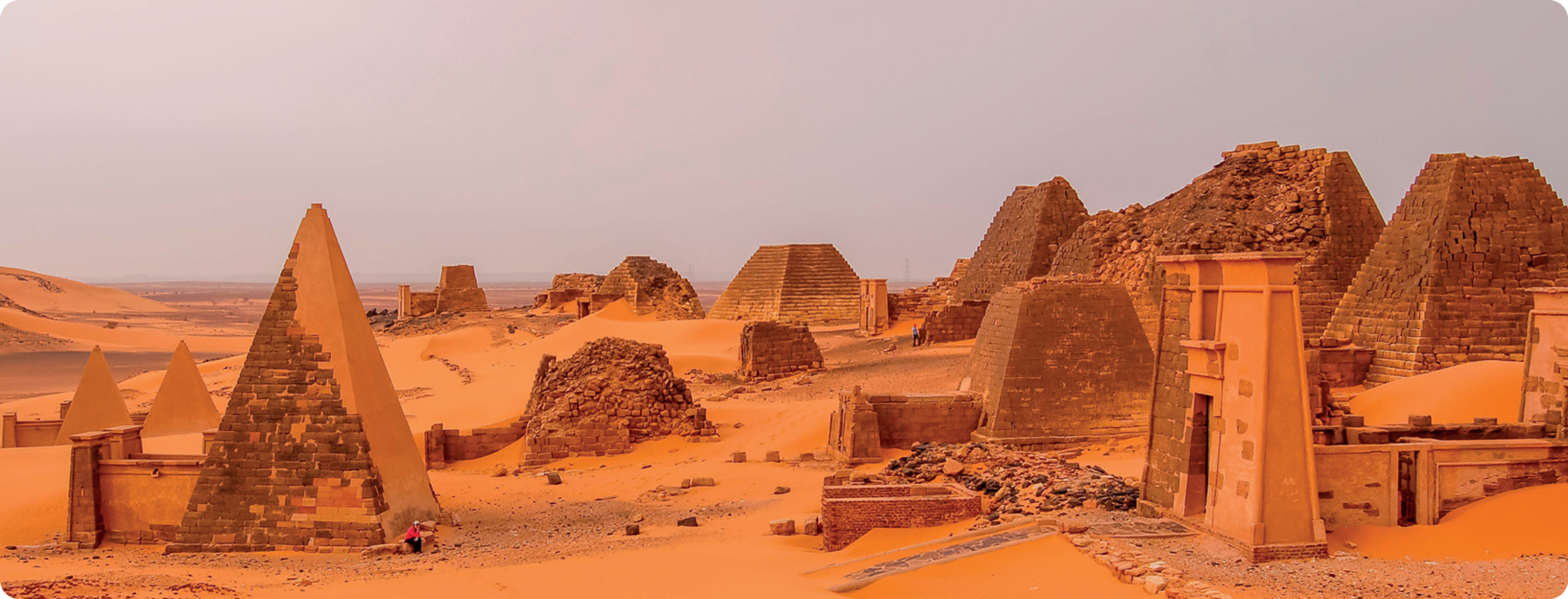 Fotografia. Ruínas de pirâmides cuxitas. À direita, ruína de um portal.