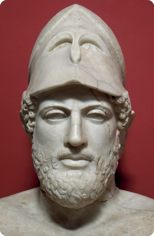 Escultura. Destacando o busto de um homem com cabelos ondulados, barba e capacete na cabeça.