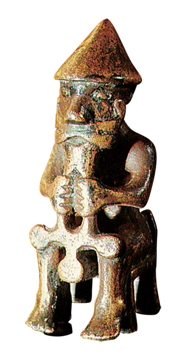 Escultura. Figura humana masculina com chapéu em formado triangular e barba, segurando com as mãos um objeto. Ele está sentado.