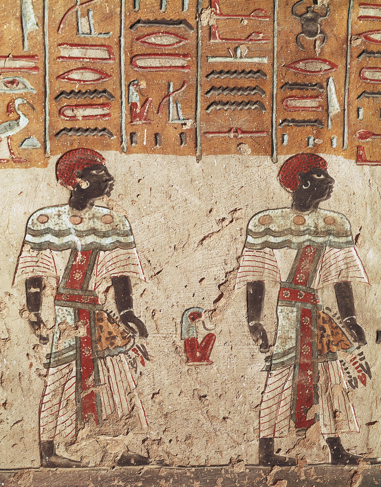 Pintura. Duas pessoas negras com chapéu vermelho, roupas coloridas e estampadas. Atrás, na parede, elementos da escrita egípcia composto por linhas e desenhos coloridos.