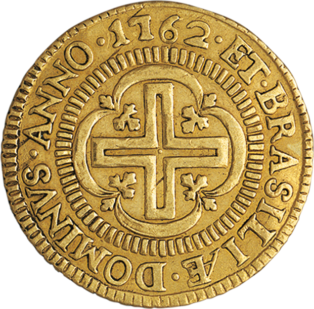 Fotografia. Verso de moeda dourada. No centro, detalhe de relevo de uma cruz. Ao redor, o texto: DOMINVS. ANNO.1762. ET.BRASILIAE.