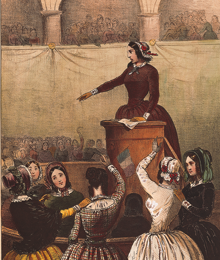 Litogravura. Uma mulher, usando chapéu e vestido vermelho, está em cima de um palanque. Ao redor, mulheres usando vestido e chapéu estão com as mãos para cima e batendo palmas.