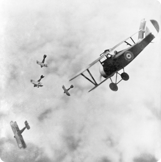 Fotografia em preto e branco. Cinco aviões pequenos voando entre as nuvens.