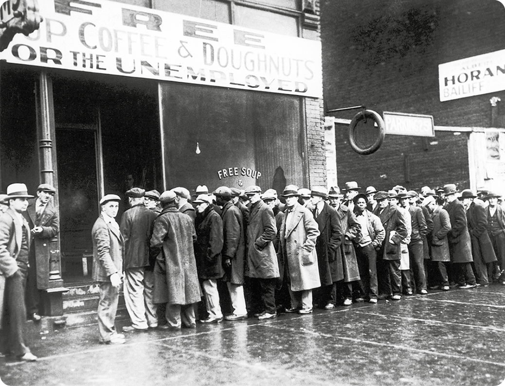 Fotografia em preto e branco. Homens usando chapéu e casaco. Eles estão em uma fila na frente de uma loja. Na placa, há o texto: Free up coffee e doughnuts for the unemployed.