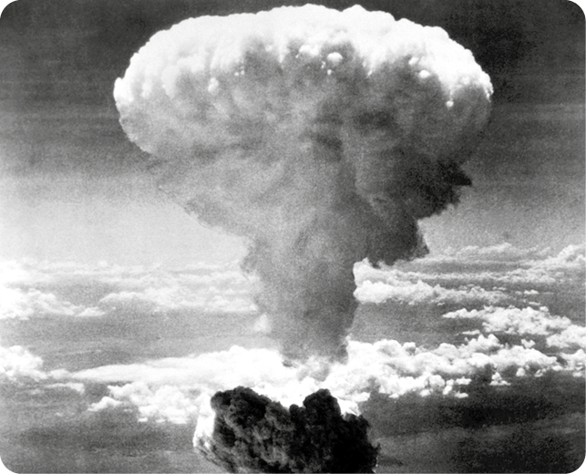 Fotografia em preto e branco. Vista da fumaça de uma explosão em formato de cogumelo.