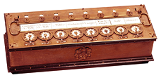 Fotografia de uma 'máquina de adições', antiga, em madeira, formato de caixa e com algumas 'teclas'.