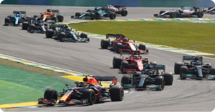 Fotografia de vários carros automobilísticos em uma corrida de Fórmula 1.