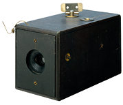 Fotografia da primeira máquina fotográfica, em formato de caixa, preta, uma abertura circular em um dos lados.