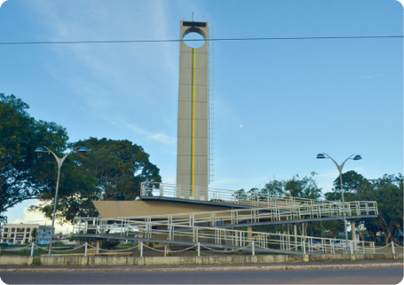 Fotografia de uma paisagem com uma rampa a frente e, atrás, uma estrutura alta, parecida com uma torre e com uma abertura circular perto de seu topo.