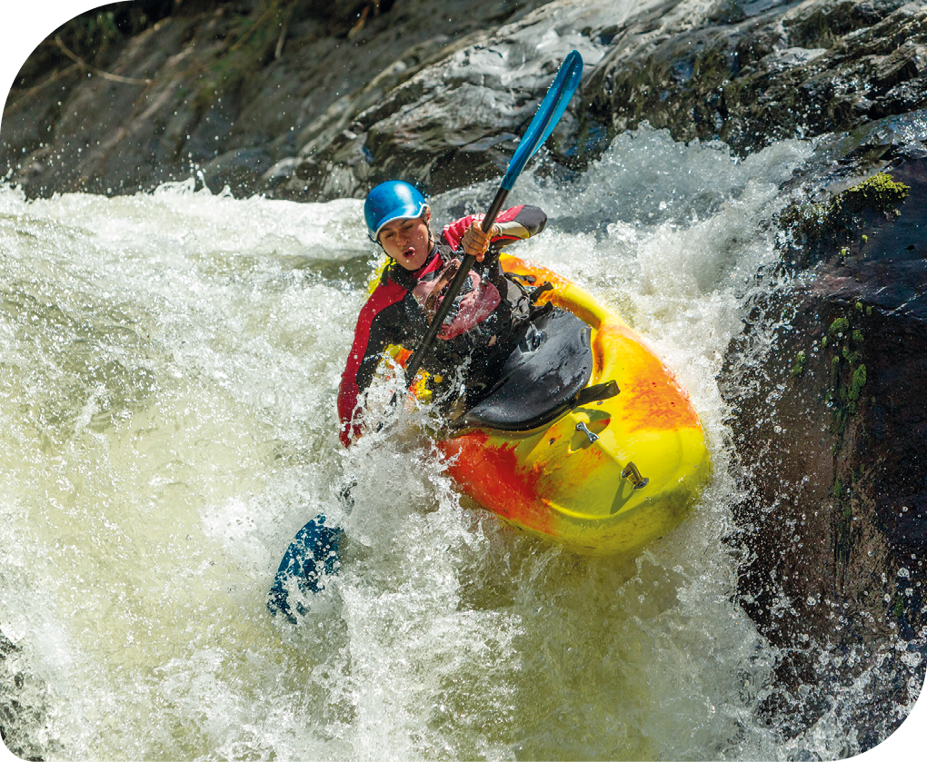 Fotografia de uma pessoa praticando canoagem em uma corredeira.