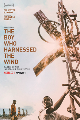 Cartaz do filme 'O menino que descobriu o vento'. O nome do filme aparece escrito em inglês ao lado do cartaz: THE BOY WHO HARNESSED THE WIND. Ao lado há um menino negro com uma espécie de engenhoca, que ocupa toda a lateral do cartaz. Ele está com as mãos sobre ela. Há um outro homem negro ao fundo que olha para o menino. O cartaz e a fotografia tem tons de marrom.