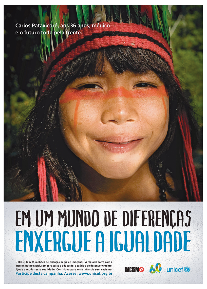 Cartaz na vertical. Na parte superior, fotografia do rosto de uma menina indígena. Ela tem cabelos longos com franja, escuros e lisos. Sobre a cabeça dela, uma faixa trançada em vermelho e, mais acima, um cocar visto parcialmente em verde. Ela tem pinturas em laranja, na horizontal, perto dos olhos e sorri. Ao fundo, local com vegetação verde. Na parte inferior, texto: EM UM MUNDO DE DIFERENÇAS ENXERGUE A IGUALDADE.  
O Brasil tem 31 milhões de crianças negras e indígenas. A maioria sofre com a discriminação racial, sem ter acesso à educação, à saúde e ao desenvolvimento. Ajude a mudar essa realidade. Contribua para uma infância sem racismo. Participe desta campanha. Acesse: www.unicef.org.br
Na parte direita, logotipos.