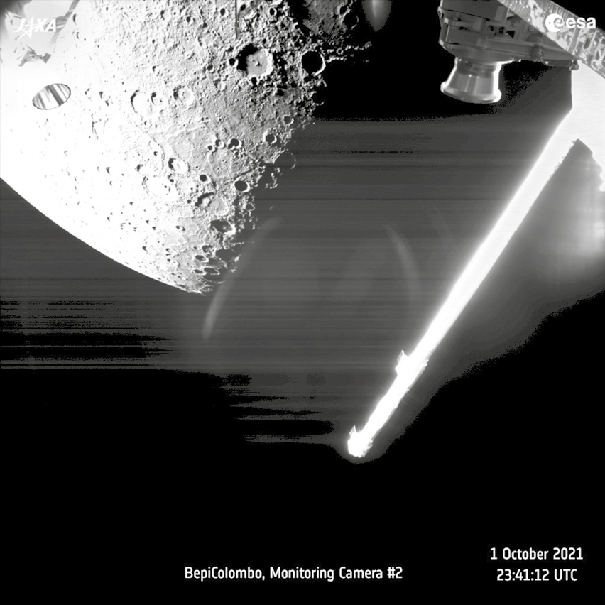 Fotografia em preto e branco. Na parte superior, vista parcial de um planeta arredondado com pequenas crateras. À direita, uma haste na diagonal, brilhosa em branco. Na parte inferior, BepiColombo, Monitoring Camera #2 1 October 2021 23:41:12 UTC