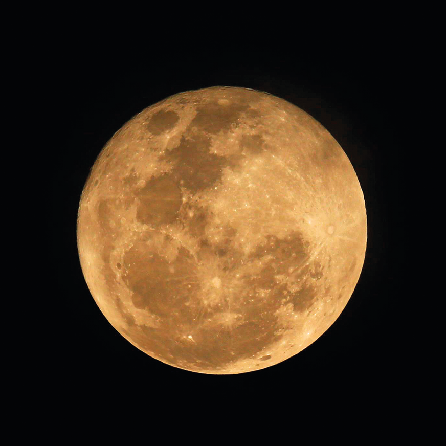 Fotografia. Captura de tela. Vista de céu noturno em preto e, ao centro, lua redonda em bege.