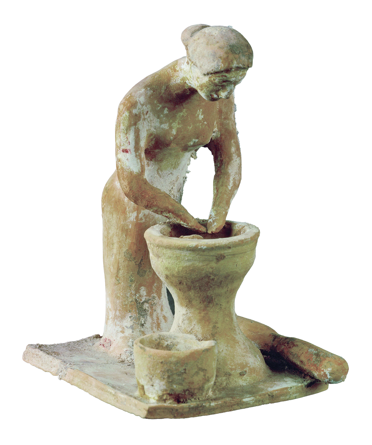 Fotografia. Escultura de uma mulher em pé encurvada com as mãos dentro de um grande recipiente com um recipiente menor ao lado.
