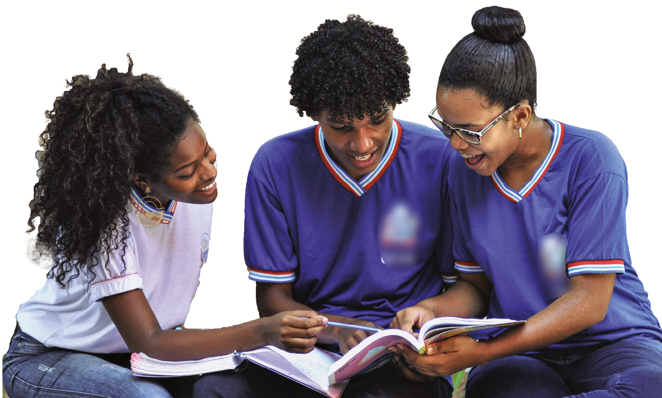 Fotografia. Três adolescentes usando uniforme escolar, sentados um ao lado do outro, leem um livro segurado pela adolescente à direita e pelo adolescente ao centro.