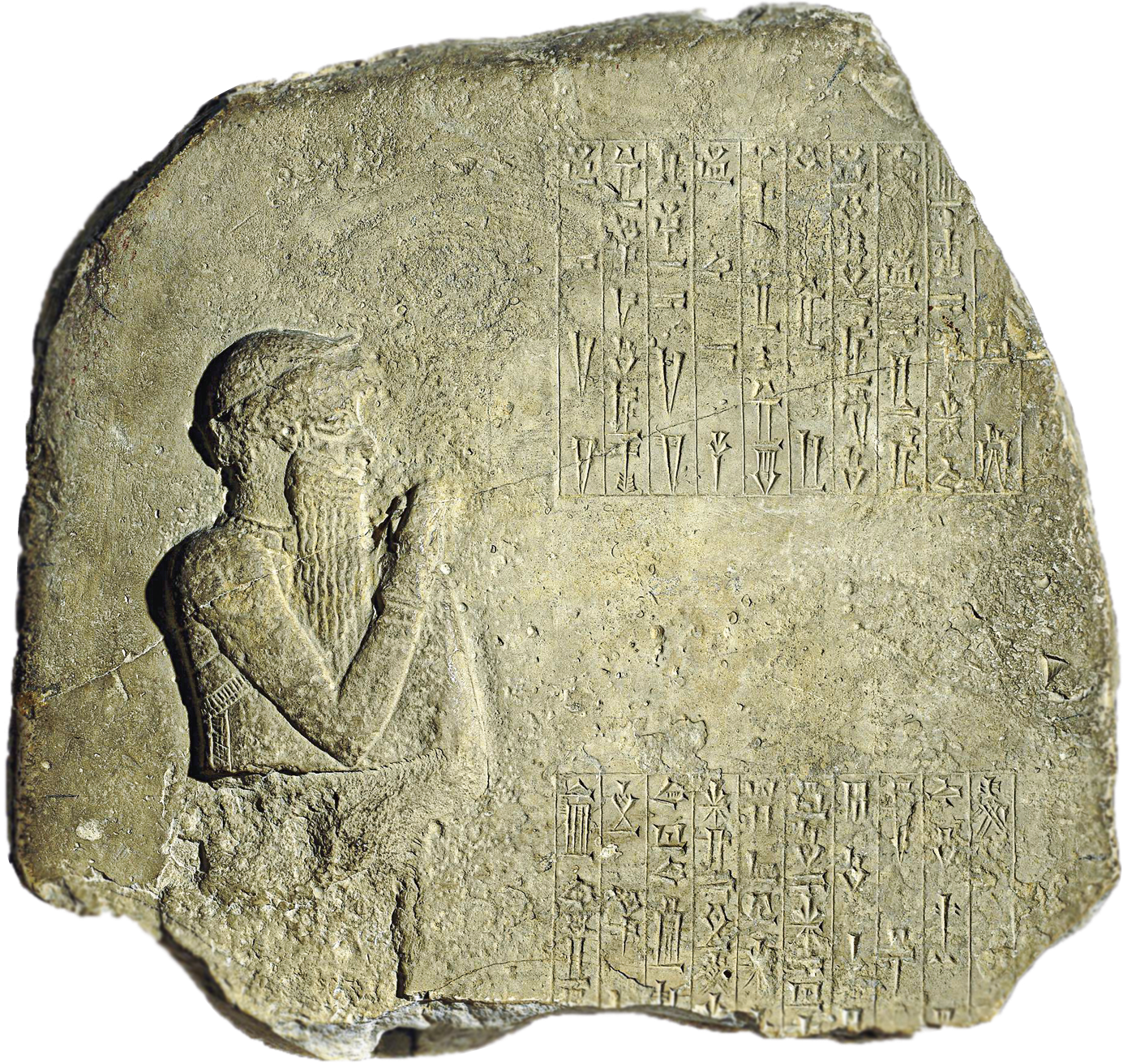 Fotografia. Pedaço de pedra de formato irregular, com desenho em alto-relevo, à esquerda, representando um homem de perfil, com barbas longas ,erguendo um dos braços e, ao lado, inscrições cuneiformes.