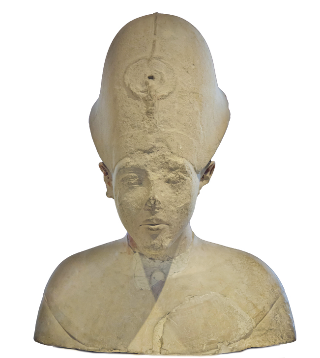 Fotografia. Busto de um homem usando um grande chapéu na cabeça. Pelo desgaste do tempo, a figura perdeu o nariz.