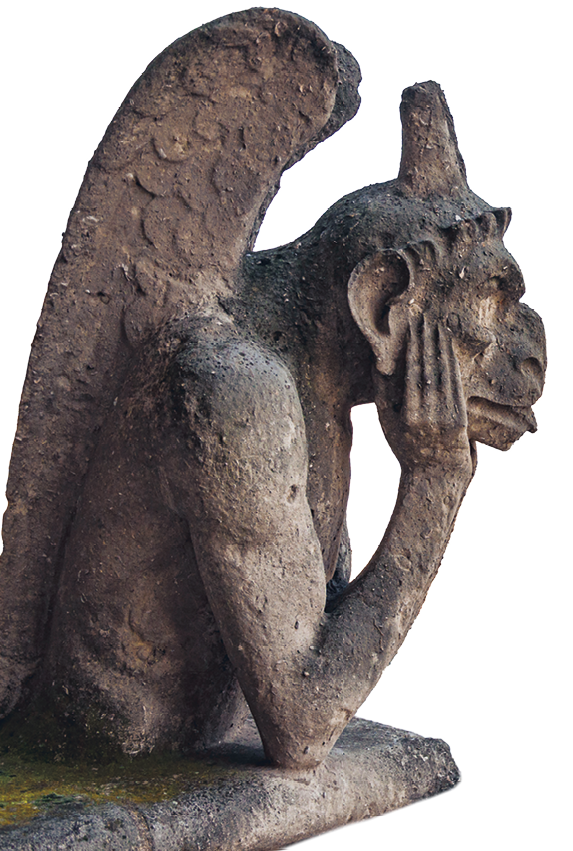 Fotografia. Escultura de pedra de uma figura com tronco humano, asas, um chifre no alto do crânio, cabeça com feições monstruosas, com o cotovelo apoiado e levando uma mão ao queixo.