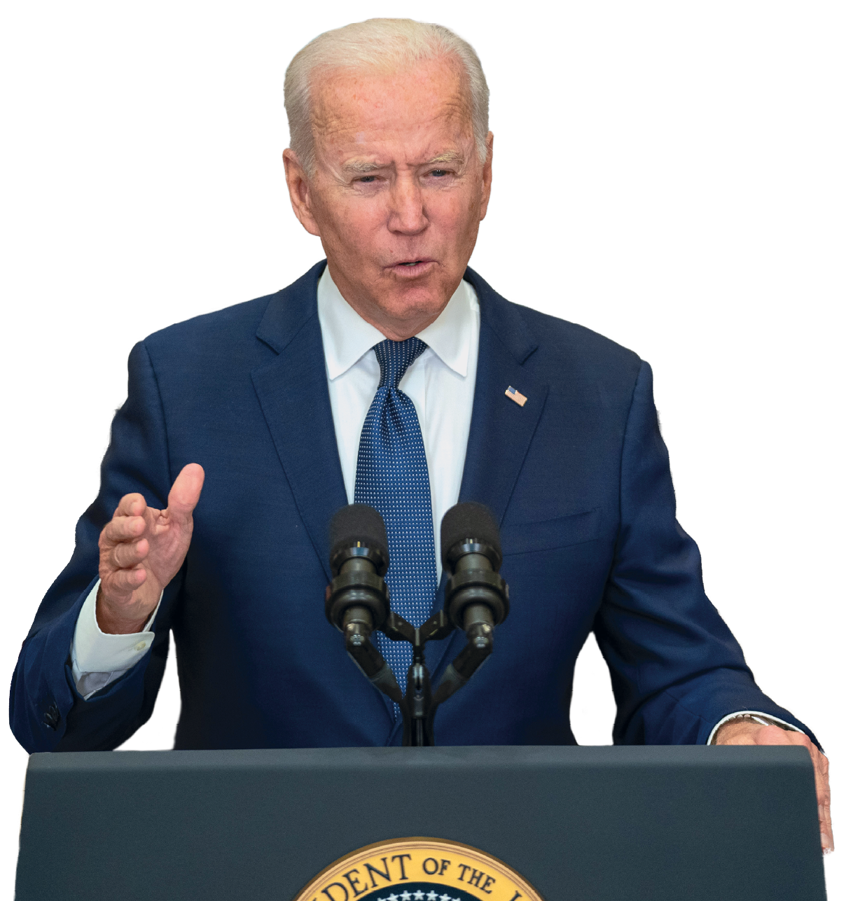 Fotografia. Homem de cabelo curto e branco, de terno azul, camisa branca e gravata em azul, discursa diante de um púlpito azul escuro com dois microfones em preto.