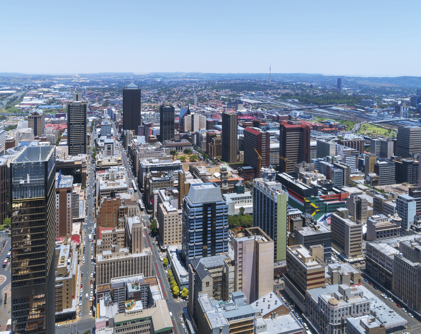 Fotografia aérea. Vista de cidade com muitos prédios, de tamanhos variados e longas avenidas.